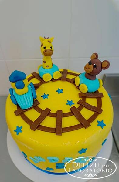 Torta Compleanno Bimbo 1 anno Milano: torta gialla con stelle azzurre e vagoni colorati con giraffa e orso